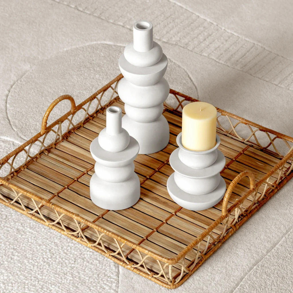 Ceramic white candle holder with lit candle outdoors