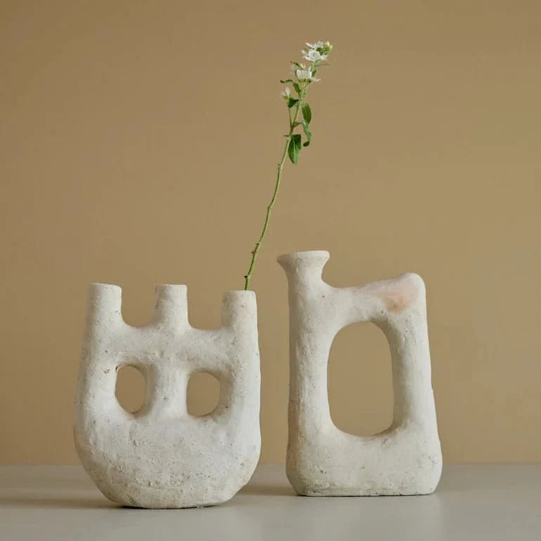 Ceramic bowls and candle holders styled together on a wooden surface