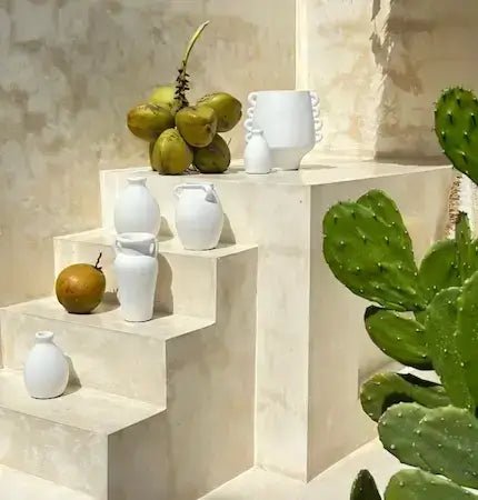 Bali collection white ceramic vases styled on textured stone steps with coconuts and cactus, Mediterranean outdoor decor