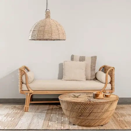 Beaded dome pendant light above a rattan daybed with linen cushions