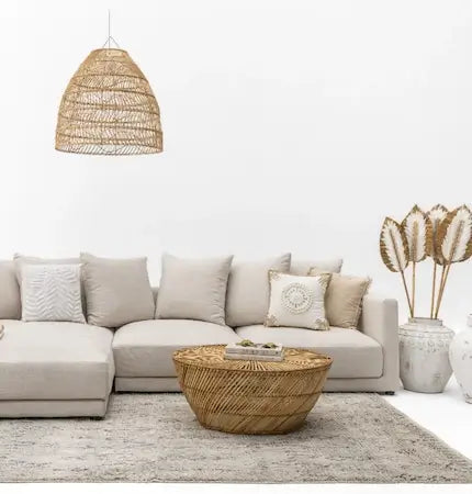 Beige L-shaped sofa with rattan pendant light and round rattan coffee table