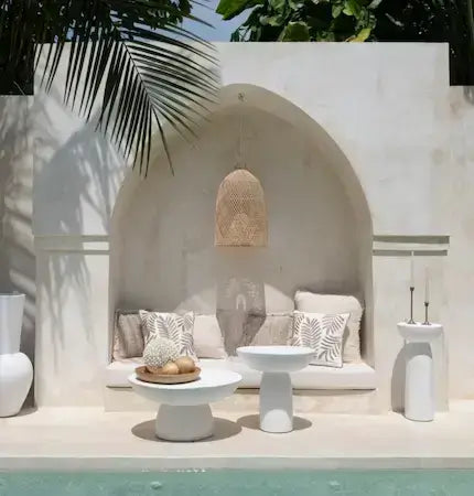 Boho style outdoor seating with white side table and neutral cushions