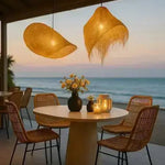 Dining area with wicker chairs, a round table, and hanging woven lamps