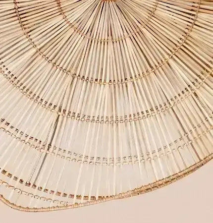 Close-up detail of a woven rattan pendant lampshade showing fan-shaped structure with concentric rings