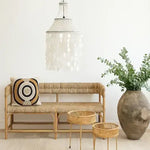 Rattan bench with decorative pillow, small tables and a large vase