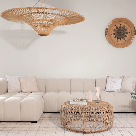 Large rattan pendant light above a cream sofa and woven coffee table