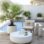 Modern outdoor decor with concrete coffee table and large ceramic vases by the pool
