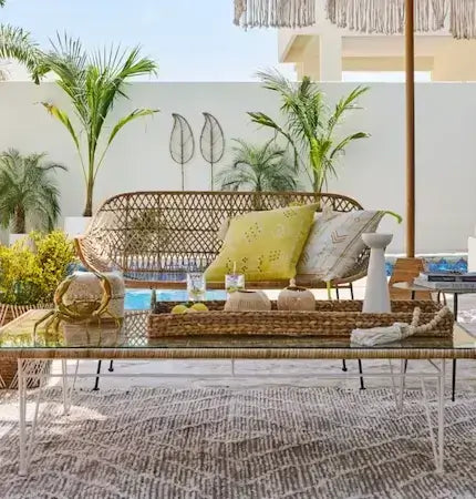 Outdoor rattan bench with glass coffee table and decorative