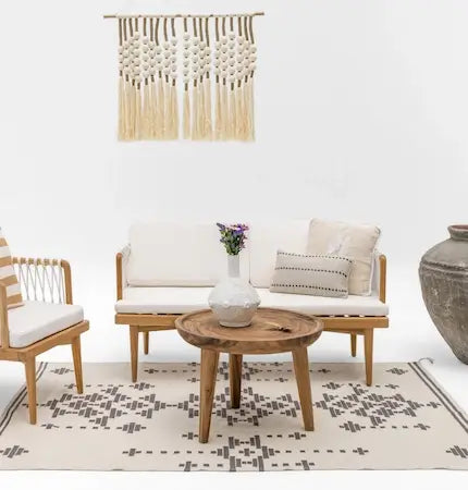  Rattan sofa with macrame wall hanging and wooden coffee table in Dubai home