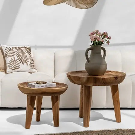  Round wooden side tables with a ceramic vase beside a white sofa in a boho Dubai living room