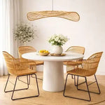 Scandinavian dining room with round white table, rattan chairs and woven pendant light