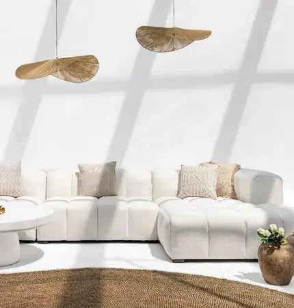 White modular corner sofa with chaise, jute rug and jute pendant lights in a natural Dubai interior