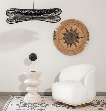 White boucle accent chair with round rattan wall decor and black pendant light