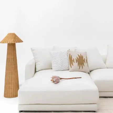  White cotton-linen sofa with rattan floor lamp in bright boho living room